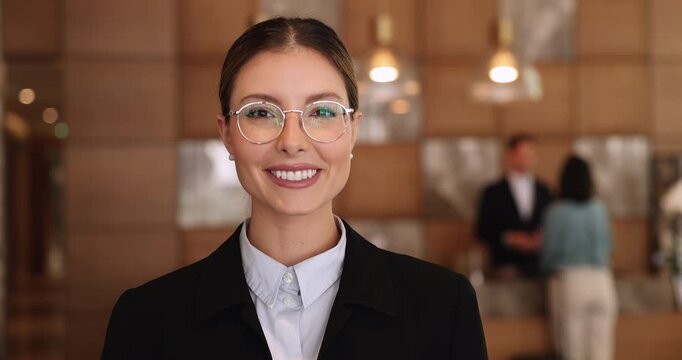 Smiling hotel receptionist posing in modern lobby