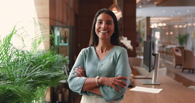 Confident hotel professional standing at reception desk