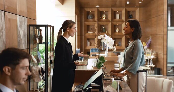 Woman guest checking in at hotel reception