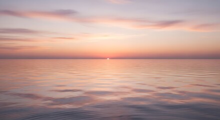 Obraz premium Serene Ocean Sunset with Soft Pink Clouds and Gentle Ripples Reflecting Light