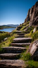 Stone steps lead up a rocky hillside in ireland, with a view of a lake and mountains in the distance, creating a scenic and peaceful landscape to explore