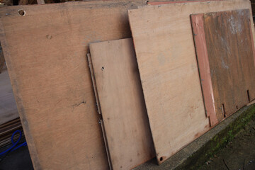 Stack of wood boards with one of them being a piece of plywood
