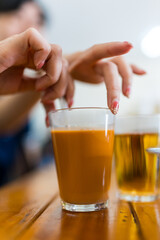 Woman stir hot Thai milk tea on wood table, signature local beverage