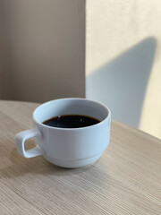 White cup of coffee on the table in a coffee shop.