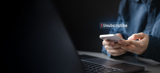 Person holding a smartphone with unsubscribe notification on screen, symbolizing cancellation of...