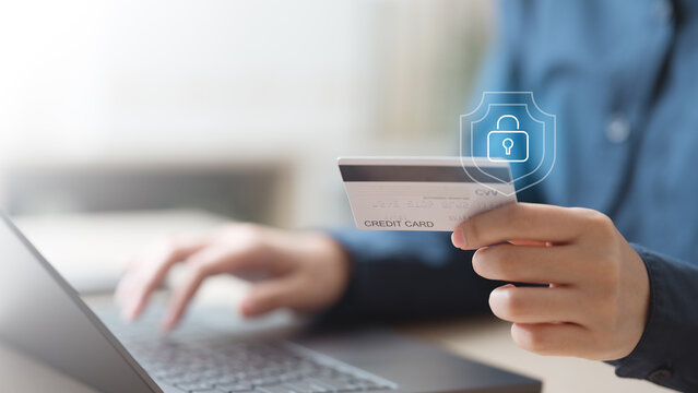 Close-up of hand holding credit card with digital lock icon, symbolizing secure online payment, fraud prevention, and financial protection in modern fintech transactions.