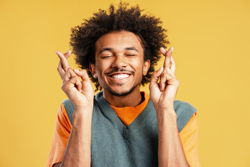 Black man smiling wishing good luck fingers crossed