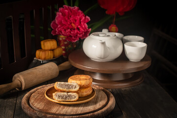 Traditional Chinese Mid-Autumn Festival mooncakes on a wooden table, dark tone.