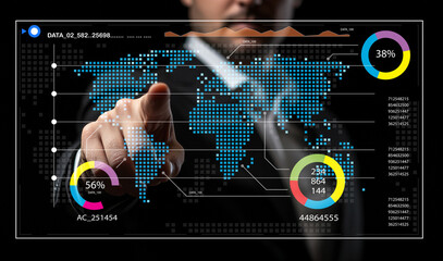 Businessman Interacting with Digital Data Visualization on Screen Featuring World Map and Statistical Charts in a Modern Office Environment