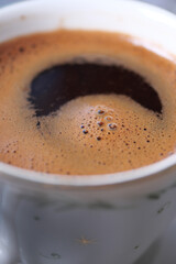 Freshly brewed coffee in a white cup on a table