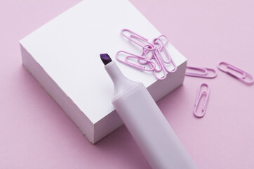 Stack of white memo papers with paper clips and marker on purple background