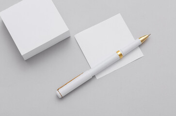 Stack of white memo papers and pen on gray background