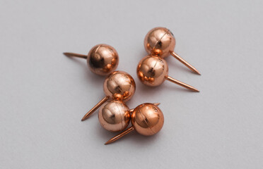 Bronze Pushpins on a Gray Background