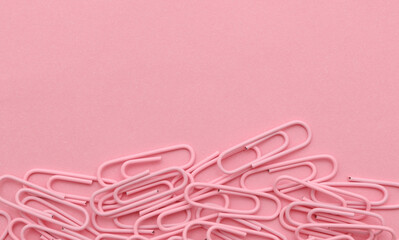 Pink paper clips on a pink background. Copy space