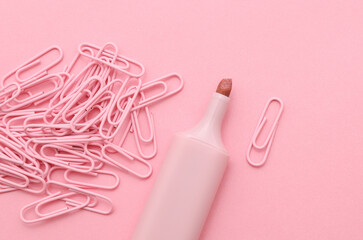 Marker and Set of pink stationery paper clips on pink background. School, office supplies