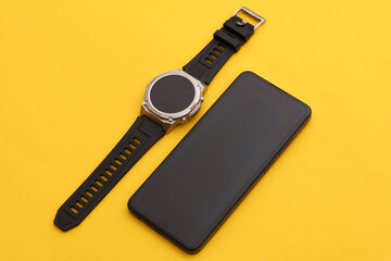 Modern gadgets. Smartphone and Smart watch on yellow background