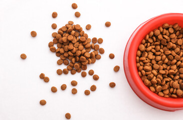 Dry cat food in a bowl on a white background