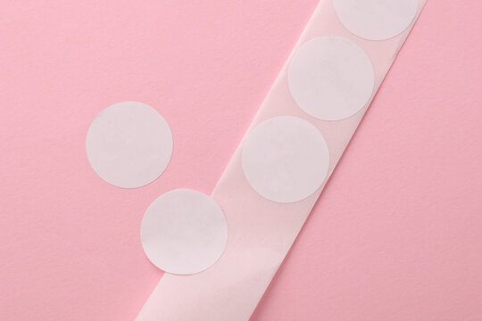 Roll of white round stickers decals on pink background. Mockup for design