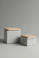 Two minimalist storage boxes made of concrete with wooden lids on a neutral gray background, showcasing modern home organization, Scandinavian design, and stylish interior decor aesthetics.
