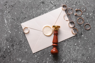 Wedding invitation. Envelope with vintage stamp with gold rings on concrete background