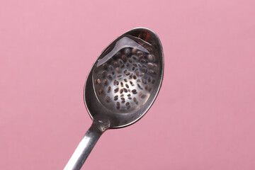 Chia seeds with water in spoon on pink background