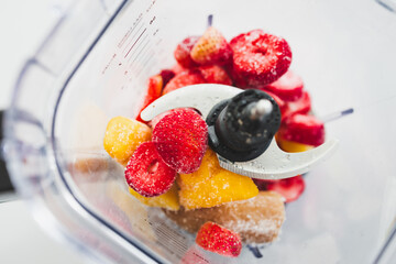 Frozen Fruit Smoothie Prep in Blender Top View with strawberries mango banana