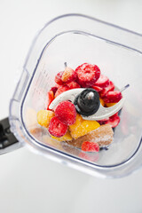 Frozen Fruit Smoothie Prep in Blender Top View with strawberries mango banana