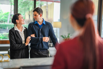 Traveler couple arrived hotel, check-in at reception area with professional front desk support....