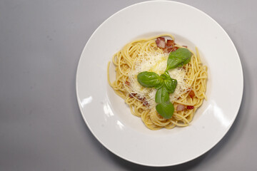 Food blogging. White plate with food placed on a gray background, leaving space for text, reflecting culinary presentation and use in social media.