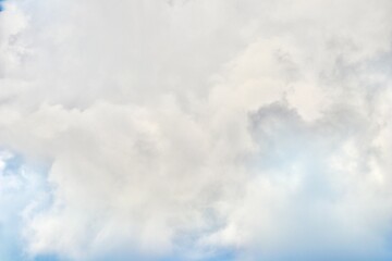 A detailed, closeup view of dense, towering cumulonimbus clouds, showing various shades of white and grey, suggesting heavy weather and dramatic atmospheric depth.
