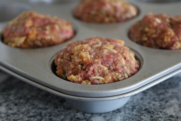Close-up of raw meatloaf muffins in pan
