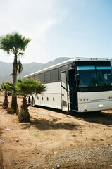 Charter tour bus parked on a dusty desert road