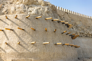 Restoration work on the historic earthen wall of the Ark Bukhara fortress in Bukhara, Uzbekistan. Reinforcing with clay and logs. Initially built the 5th century AD. 16th century CE present structure