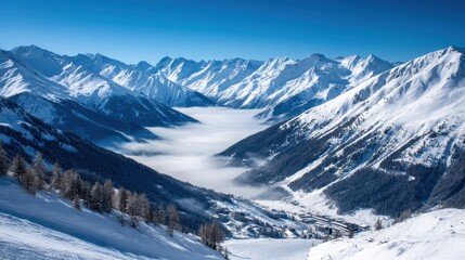 Majestic mountain range landscape with snow capped peaks and a sea of clouds in a scenic winter panorama from above