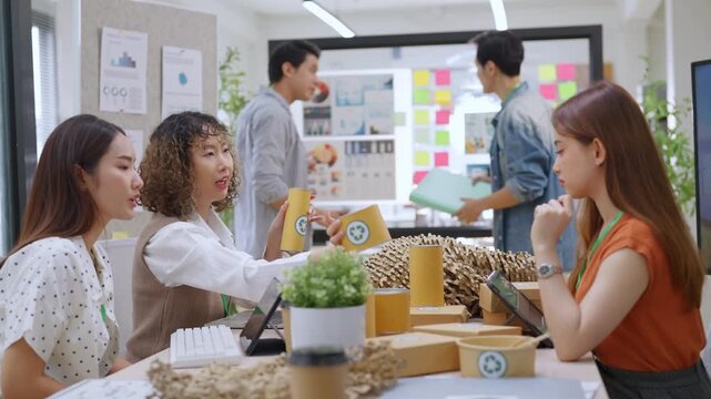 Creative business  product developers actively brainstorm ideas, sharing discussions ESG  green energy focusing on product repackaging and reuse strategies to reduce costs maximize profit business