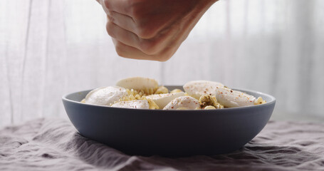 add spices to mozzarella with fusilli pasta with pesto in blue bowl