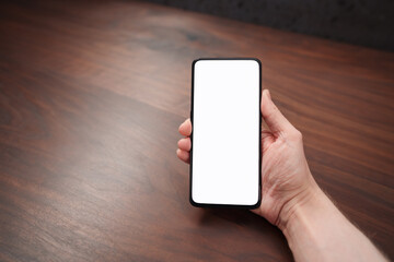 Man hand hold phone with white screen over black walnut table background