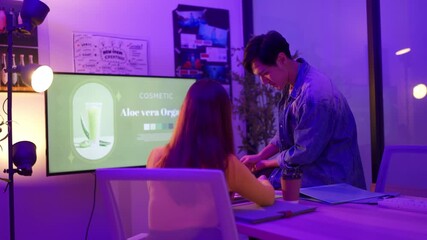 Creative product developers and package designers collaborate overnight in a modern office, brainstorming ideas, reviewing screen mockups, and analyzing graphic charts together with full teamwork - Powered by Adobe