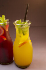 Two elegant glass pitchers filled with colorful beverages, garnished with fresh mint leaves for a lovely presentation
