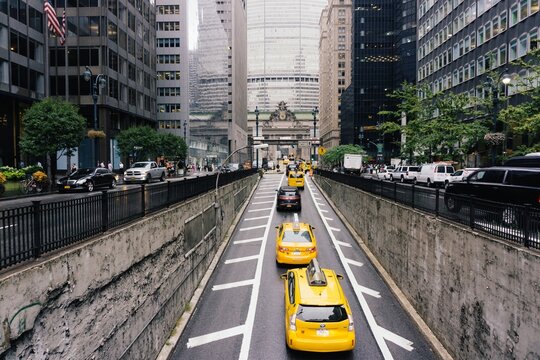 New York City street view, iconic yellow taxi cabs coming out of park avenue tunnel headed to grand central station