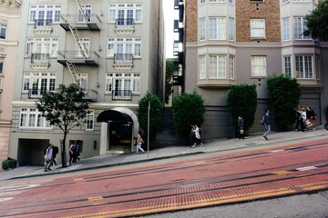 San Francisco street with people walking up and down the steep slopes, tram track in foreground © Eepeng