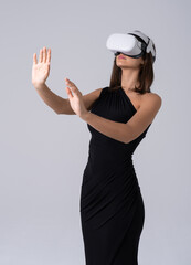 Woman exploring virtual reality with VR headset, wearing elegant