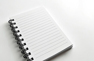 A blank spiral notebook with lined pages rests on a clean white surface. Its open pages invite writing, drawing, or planning. This minimalist stationery item is ready for creative ideas.
