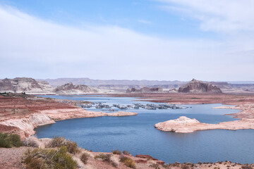 Panoramic view of Lake Powell in Arizona with Wahweap Marina and sandstone cliffs. The blue water contrasts with the red desert landscape, creating a stunning Southwestern USA travel scene.
