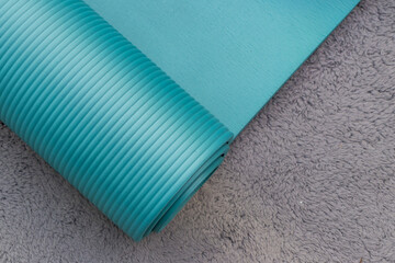  Blue yoga mat rolled up on floor, fitness equipment for exercise, workout, stretching and home training