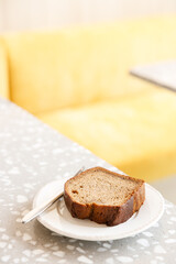 Moist Peanut butter Banana bread sliced with sauce on ceramic plate by the window.