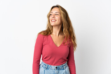 Fototapeta premium Young blonde woman isolated on blue background looking to the side and smiling