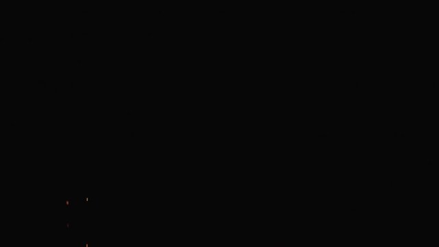 Slow motion of sparks and embers from campfire flying over black background