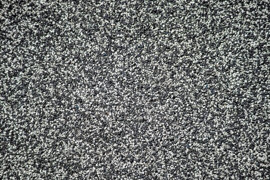 Closeup of black and white rubber granule surface used on playgrounds. Eco-friendly, shock-absorbing flooring for children&rsquo;s safety.