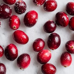 A close-up captures the vibrant, glistening texture of fresh cranberries scattered across a cool, inviting surface.